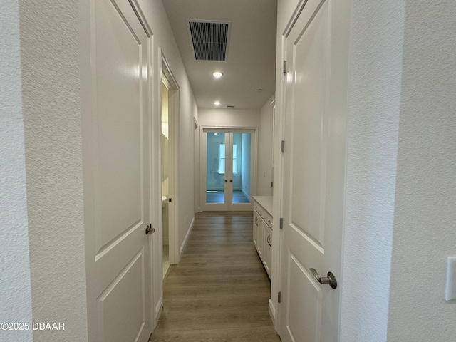 2009 Divot Dr, Daytona Beach, FL 32124 - hallway with visible vents, baseboards, wood finished floors, french doors, and a textured wall