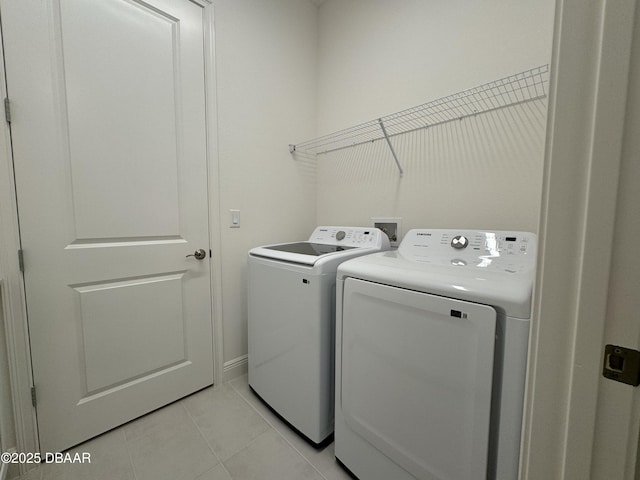 2009 Divot Dr, Daytona Beach, FL 32124 - laundry room featuring light tile patterned floors, laundry area, and separate washer and dryer