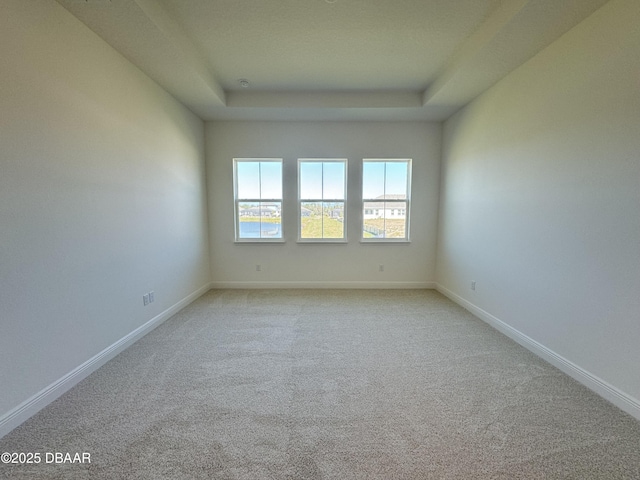 2009 Divot Dr, Daytona Beach, FL 32124 - empty room with a tray ceiling, baseboards, and light colored carpet