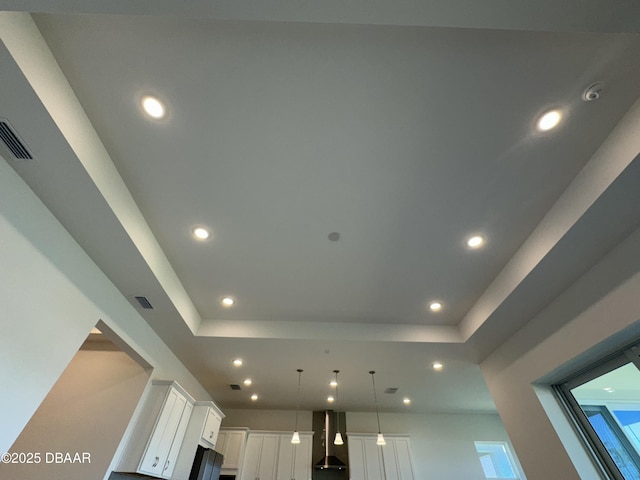 2009 Divot Dr, Daytona Beach, FL 32124 - room details with visible vents, a tray ceiling, recessed lighting, white cabinetry, and wall chimney exhaust hood