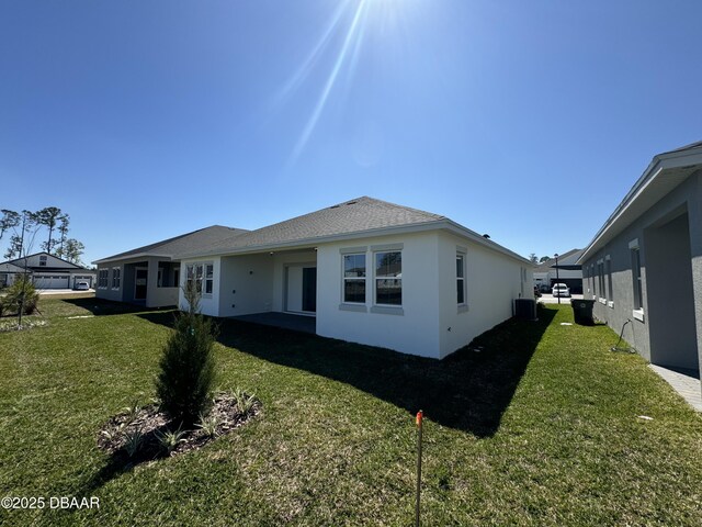2009 Divot Dr, Daytona Beach, FL 32124 - back of house with a lawn, central AC, and stucco siding
