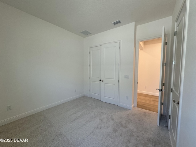 2009 Divot Dr, Daytona Beach, FL 32124 - unfurnished bedroom with baseboards, visible vents, a closet, a textured ceiling, and carpet flooring