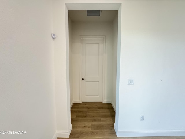 2009 Divot Dr, Daytona Beach, FL 32124 - hallway featuring visible vents, baseboards, and wood finished floors