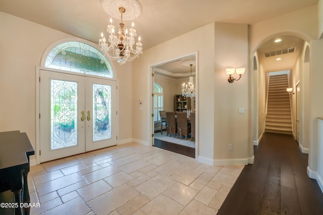 entryway featuring stairway, visible vents, baseboards, an inviting chandelier, and french doors