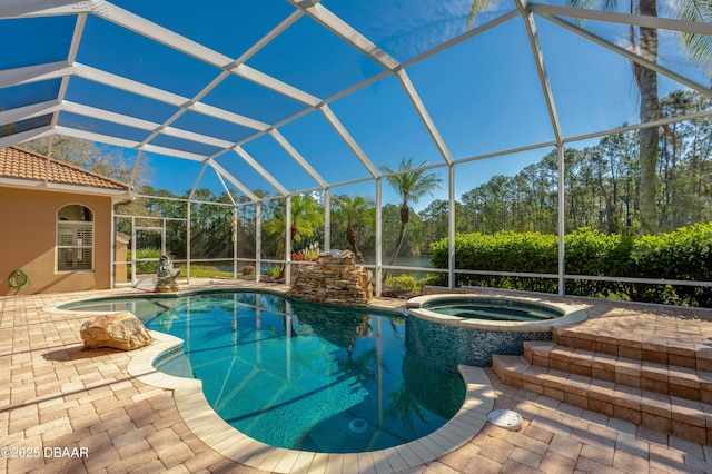 view of pool featuring glass enclosure, a pool with connected hot tub, and a patio