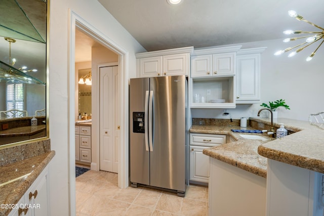 kitchen featuring open shelves, an inviting chandelier, white cabinets, stainless steel fridge with ice dispenser, and light stone countertops