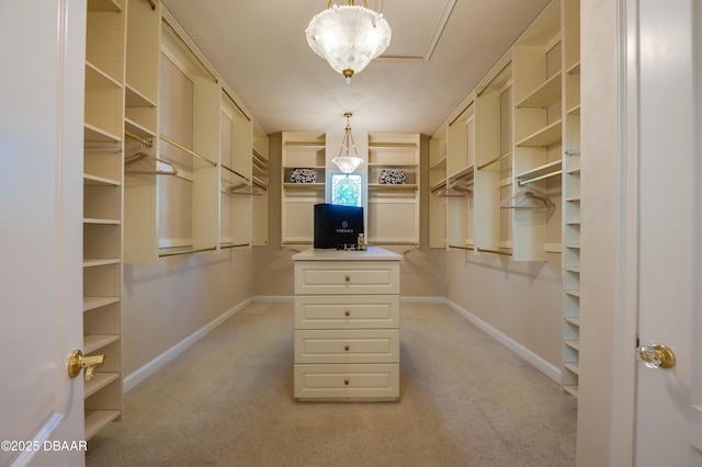 spacious closet featuring a notable chandelier and light colored carpet