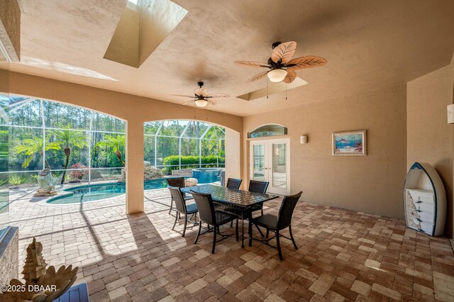 view of patio featuring glass enclosure, a ceiling fan, outdoor dining area, an outdoor pool, and french doors