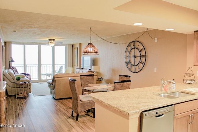 kitchen with expansive windows, dishwasher, sink, ceiling fan, and light hardwood / wood-style flooring