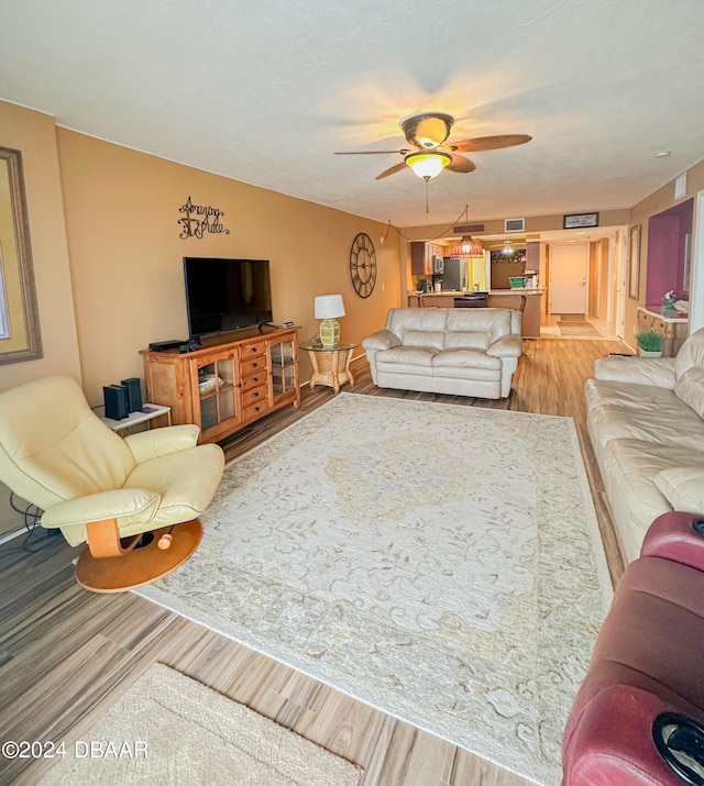 living room with light wood-type flooring and ceiling fan