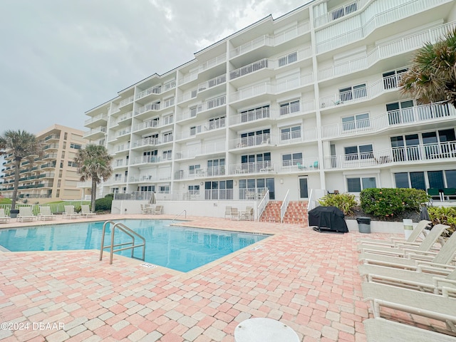 view of swimming pool with area for grilling and a patio