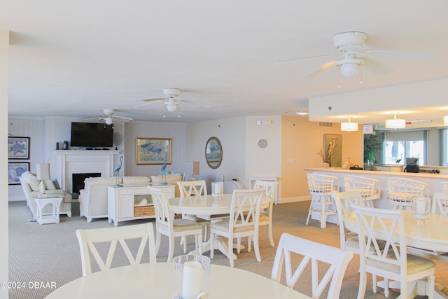 carpeted dining room featuring ceiling fan