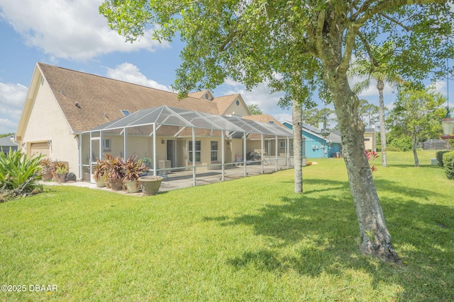 rear view of house with a lawn, a patio, and glass enclosure