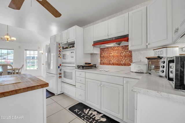 kitchen with pendant lighting, white appliances, tasteful backsplash, white cabinets, and light tile patterned flooring