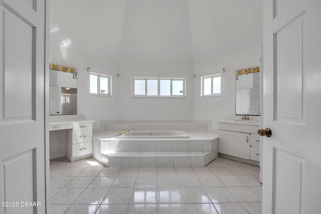 bathroom featuring vanity, tile patterned floors, tiled bath, and a healthy amount of sunlight