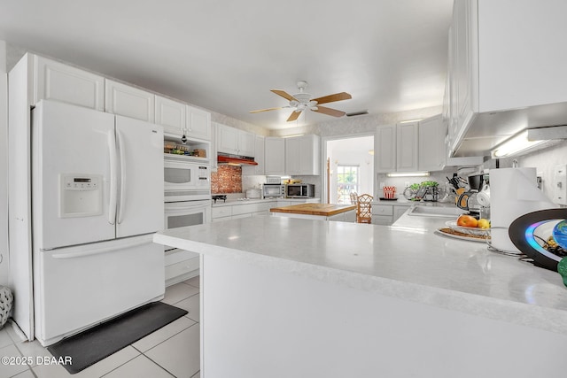 160 Big Ben Dr, Daytona Beach, FL 32117 - kitchen with light countertops, a peninsula, white appliances, a ceiling fan, and white cabinetry