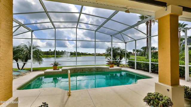 view of pool with glass enclosure, a water view, and a patio