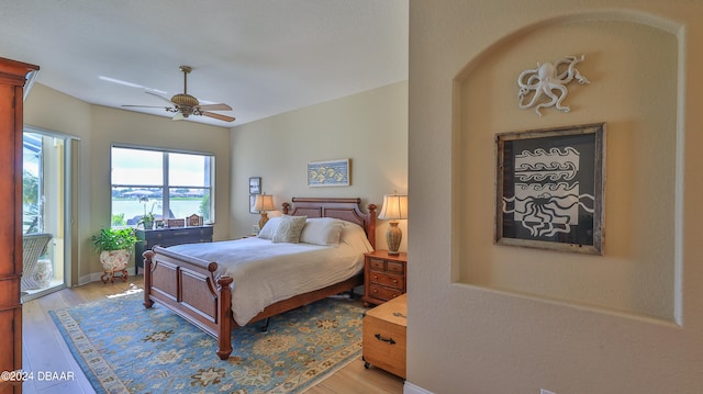 bedroom with access to exterior, light hardwood / wood-style flooring, and ceiling fan