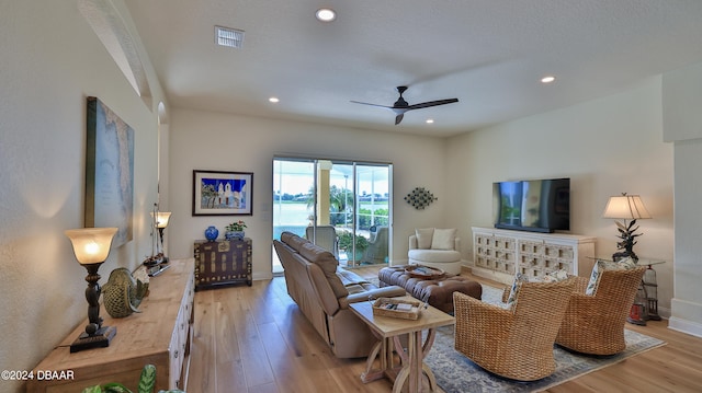 living room with ceiling fan and light hardwood / wood-style floors