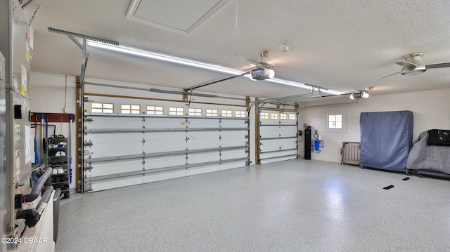 garage with a garage door opener and ceiling fan