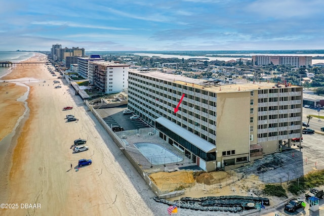 drone / aerial view with a water view and a beach view