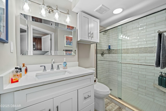 bathroom featuring vanity, toilet, and an enclosed shower