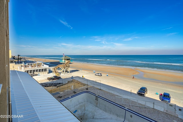 view of pool featuring a water view and a beach view