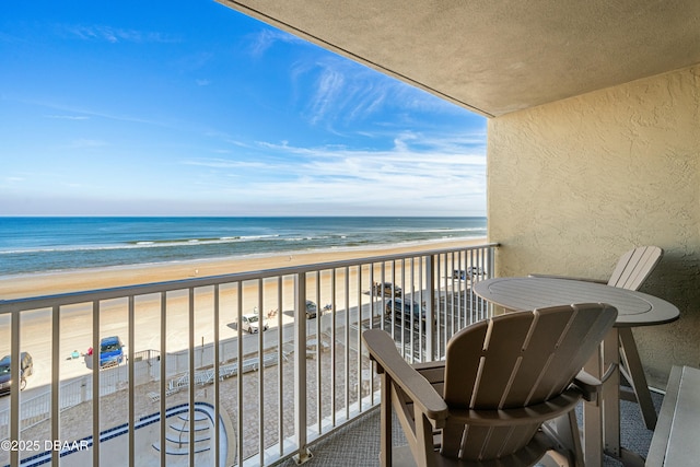 balcony with a water view and a beach view