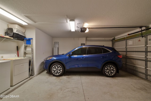 garage with independent washer and dryer and a garage door opener