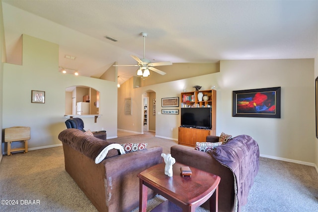 carpeted living room with ceiling fan and vaulted ceiling