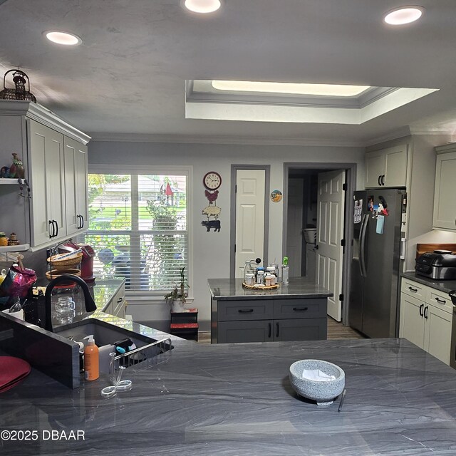 1010 Bolton Rd, New Smyrna Beach, FL 32168 - kitchen with crown molding, refrigerator with ice dispenser, a raised ceiling, and dark countertops