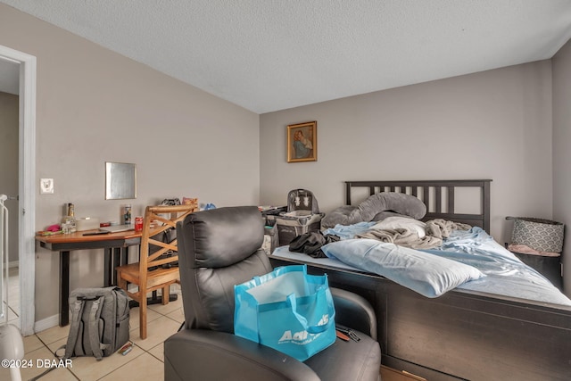 bedroom with a textured ceiling and light tile patterned floors