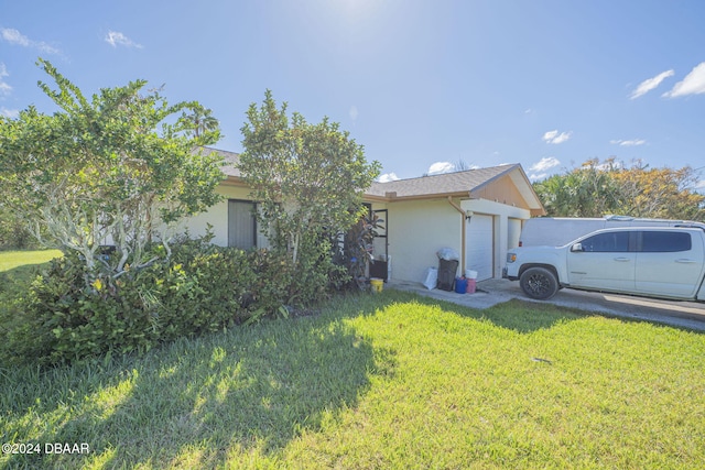 view of side of home featuring a garage and a yard