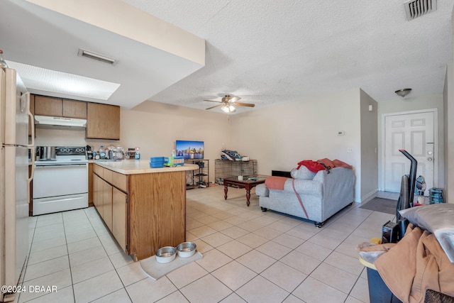 kitchen with kitchen peninsula, ceiling fan, white appliances, and light tile patterned floors