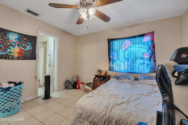 tiled bedroom with ceiling fan and a textured ceiling