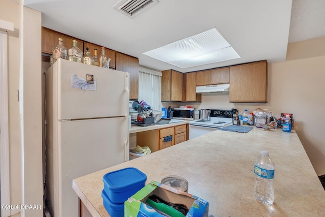 kitchen featuring kitchen peninsula and white appliances