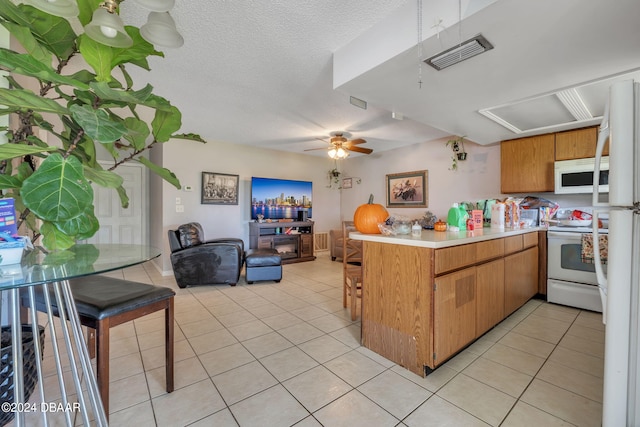 kitchen featuring kitchen peninsula, ceiling fan, white appliances, and light tile patterned flooring