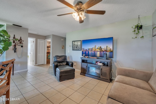 tiled living room with a textured ceiling and ceiling fan