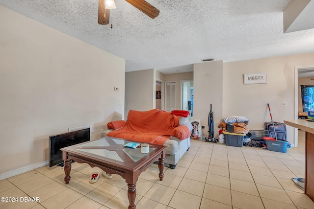 tiled living room featuring a textured ceiling and ceiling fan