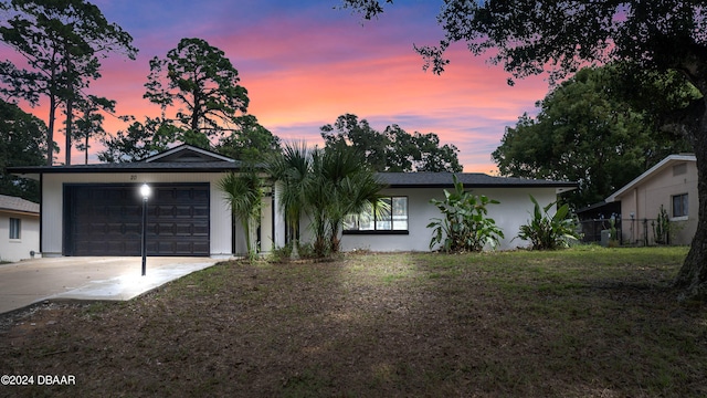 single story home with a garage and a lawn