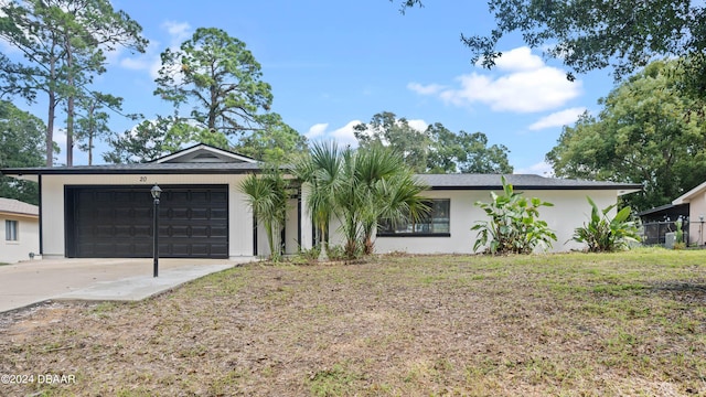 single story home featuring a garage and a front lawn