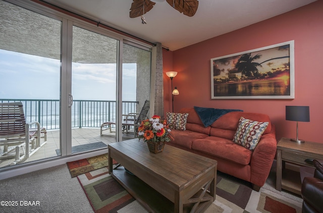 3311 S Atlantic Ave Unit 602, Daytona Beach Shores, FL 32118 - carpeted living room featuring a water view, ceiling fan, and floor to ceiling windows