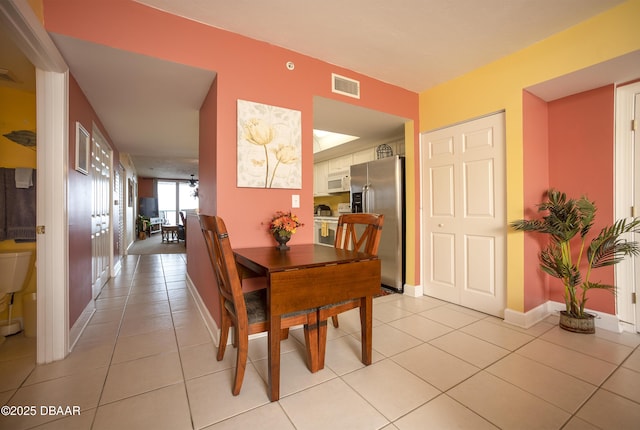 3311 S Atlantic Ave Unit 602, Daytona Beach Shores, FL 32118 - kitchen with white appliances, a chandelier, a sink, light tile patterned floors, and white cabinets