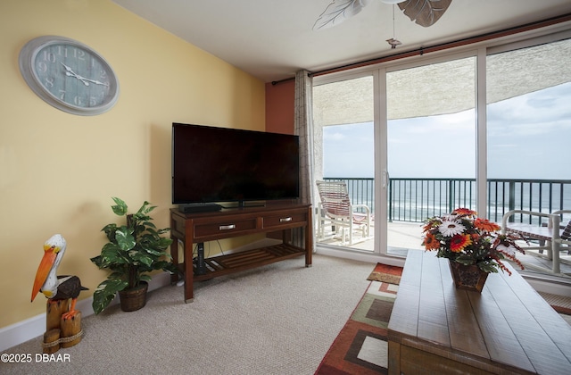 3311 S Atlantic Ave Unit 602, Daytona Beach Shores, FL 32118 - living room featuring carpet flooring, a ceiling fan, and expansive windows