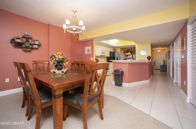 3311 S Atlantic Ave Unit 602, Daytona Beach Shores, FL 32118 - dining area featuring a chandelier, baseboards, and light tile patterned flooring