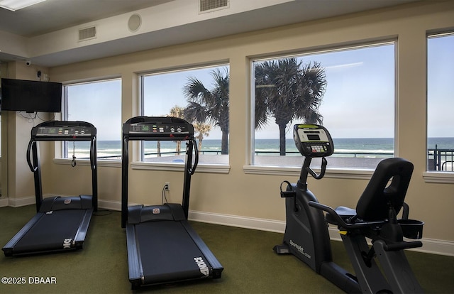 3311 S Atlantic Ave Unit 602, Daytona Beach Shores, FL 32118 - exercise area with dark colored carpet, baseboards, and a water view