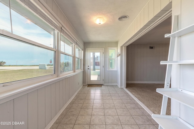 3622 Ocean Shore Blvd, Ormond Beach, FL 32176 - doorway to outside with a textured ceiling and wooden walls