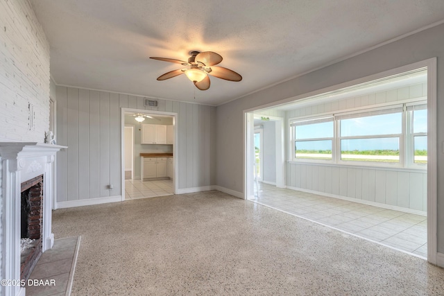 3622 Ocean Shore Blvd, Ormond Beach, FL 32176 - unfurnished living room featuring a ceiling fan, a fireplace, crown molding, and dark aggregate flooring
