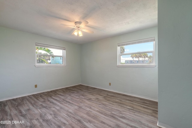 3622 Ocean Shore Blvd, Ormond Beach, FL 32176 - empty room with healthy amount of natural light, a textured ceiling, wood finished floors, and a ceiling fan