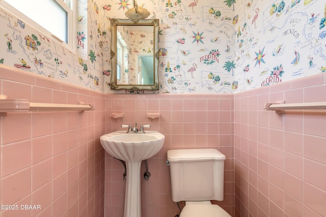 3622 Ocean Shore Blvd, Ormond Beach, FL 32176 - bathroom with wallpapered walls, a wainscoted wall, and tile walls
